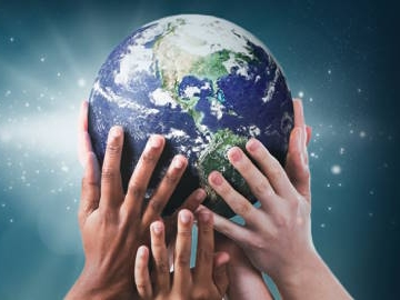Many hands holding up the planet Earth